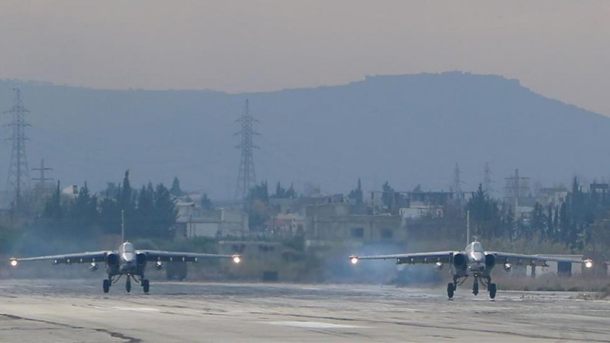 Dos aviones de combate Sukoi Su-25 rusos, en diciembre del 2015, despegando en la base militar de Hmeimim, en el noroeste de Siria.-AFP / PAUL GYPTEAU