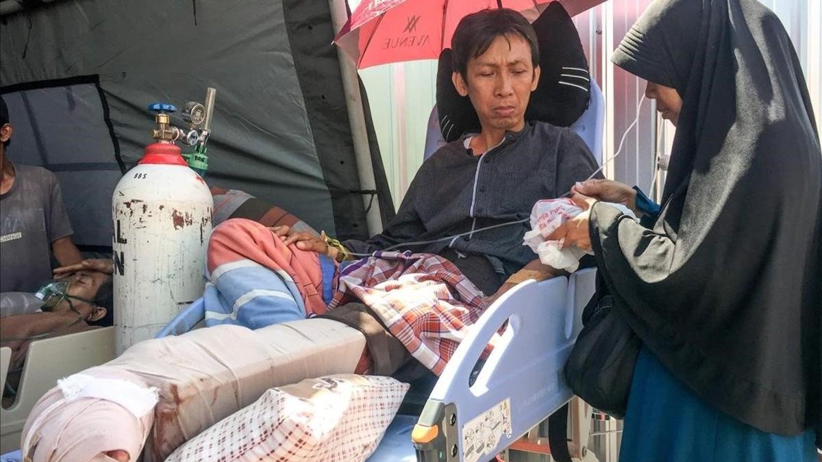Una mujer atiende a su marido, herido en el terremoto de Lombok, en el hospital de Mataram.  /-KIKI SIREGAR (AFP)