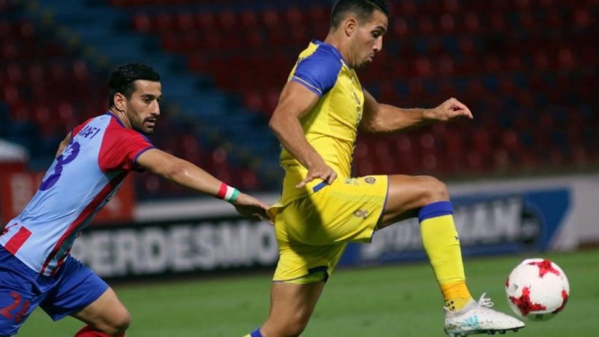 El jugador iraní Ehsan Hajsafí, del Panionios (a la izquierda) disputa el balón con Eyal Golasa, del Maccabi, en el partido disputado en Atenas el pasado día 3.-EFE