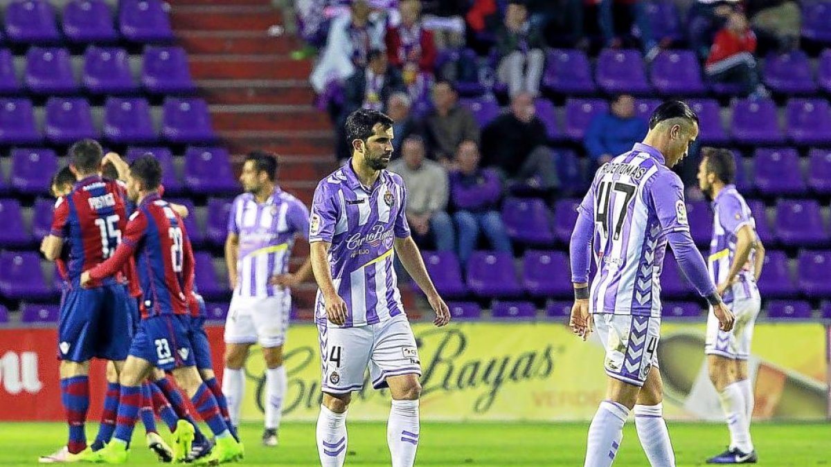 Jugadores del Real Valladolid lamentan uno de los cuatro goles del Levante, que lo festeja.-J.M.LOSTAU