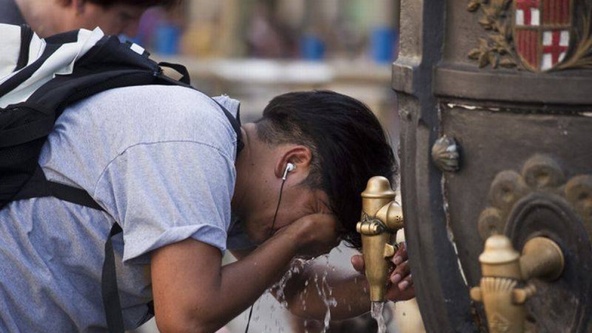 Un turista se refresca en la fuente de Canaletes durante una ola de calor.-Foto: ARCHIVO / JOAN PUIG