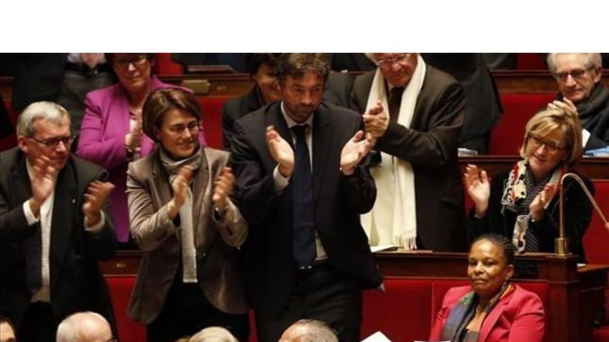 Diputados franceses aplauden a la ministra de Justicia, Christiane Taubira (derecha), antes de votar la ley, este martes en París.-CHARLES PLATIAU / REUTERS