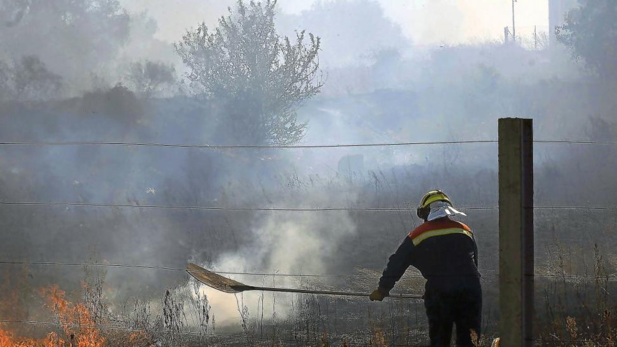 Un bombero durante las labores de extinción del incendio declarado ayer a pocos kilómetros de León.-ICAL