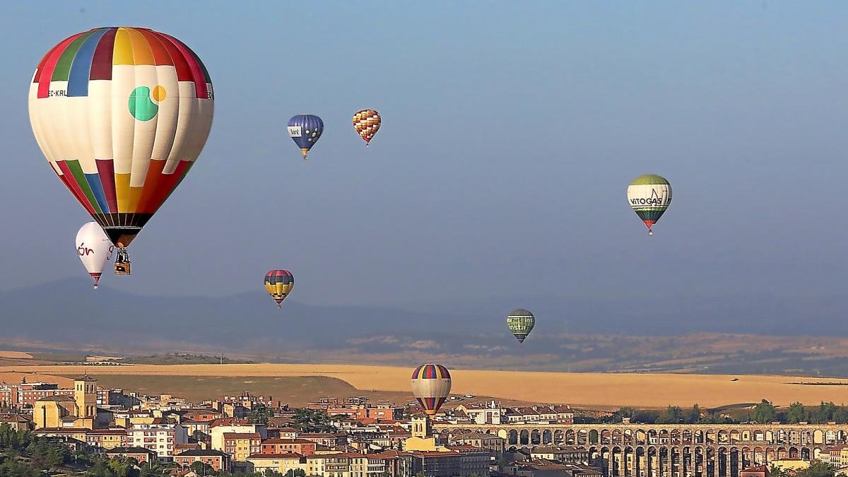 Los globos aerostáticos sobrevuelan la ciudad de Segovia con el Acueducto al fondo.-ICAL