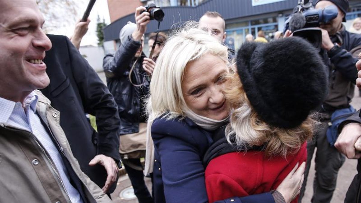 Marine Le pen abraza a una admiradora a la salida del colegio electoral tras ejercer el derecho al voto.-EFE/EPA/JULIEN WARNAND