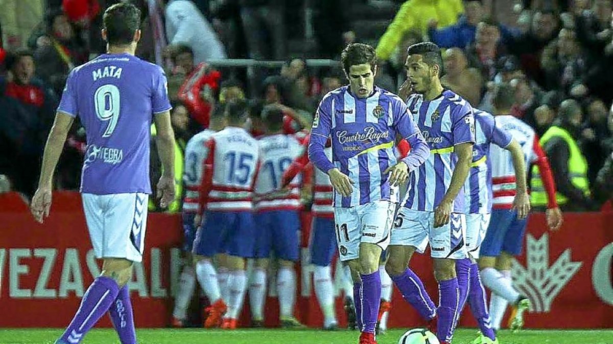 Los jugadores del Granada celebran el gol, al fondo, ante la decepción de Mata, Hervías y Anuar, anoche en Los Cármenes.-PHOTO-DEPORTE