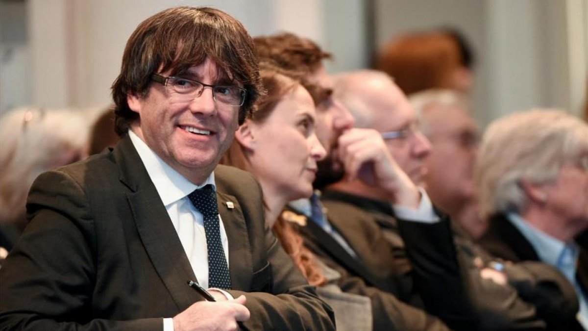 Puigdemont, acompañado de los cuatro exconsellers que están con él en Bruselas, en el acto con los alcaldes.-/ PERIODICO (AFP / JOHN THYS)