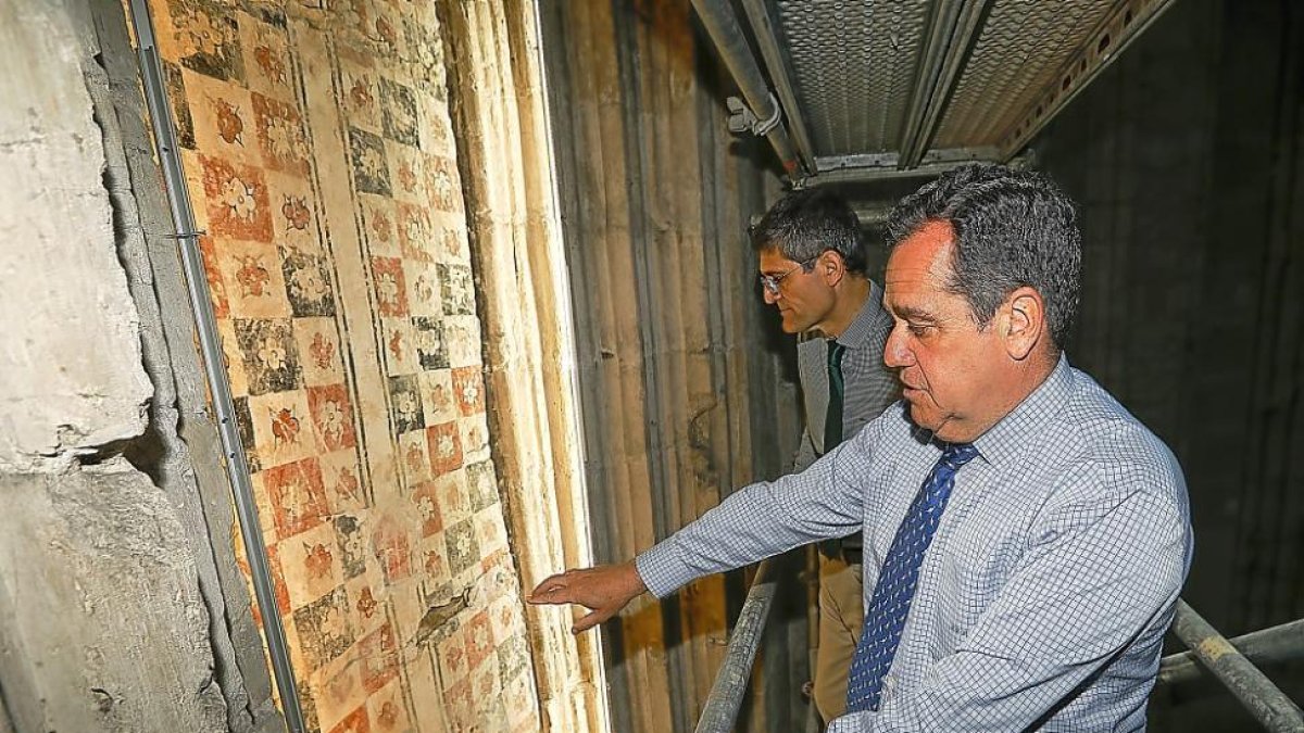 Pablo Trillo y Leopoldo Cortejoso observan los motivos que decoran los vanos del ábside.-J.M. LOSTAU