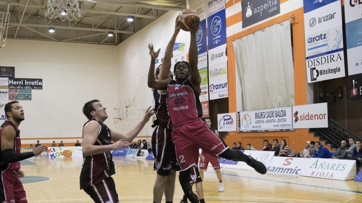 Gantt penetra y recibe un tapón de Salazar ayer en el duelo que jugó el Carramimbre en Azpeitia.-ÓSCAR BLANCO / PHOTODEPORTE
