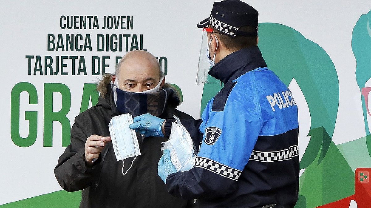 JUAN MIGUEL LOSTAU. 13/04//2020. VALLADOLID. COMUNIDAD DE CASTILLA Y LEÓN. CORONAVIRUS. LUNES 13. POLICÍA MUNICIPAL REPARTE MASCARILLAS A LOS USUARIOS DE AUTOBUSES URBANOS EN LA PLAZA DE ESPAÑA
