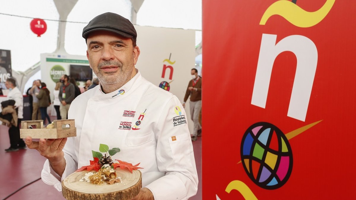 El presidente del jurado nacional, y copresidente del Mundial, Jesús Sánchez, sostiene dos de los pinchos participantes. J.M. LOSTAU