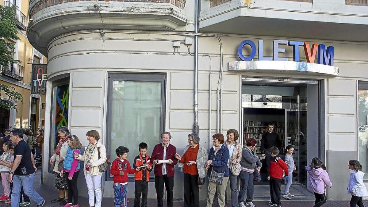 Una cadena humana para el traslado de libros de la librería Oletvm de Valladolid al nuevo local.-ICAL