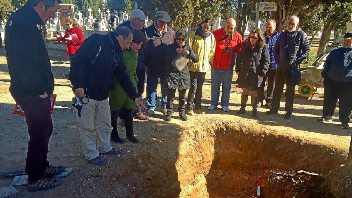 El arqueólogo Julio del Olmo muestra a la concejala María Sánchez los restos en la fosa.-E. M.