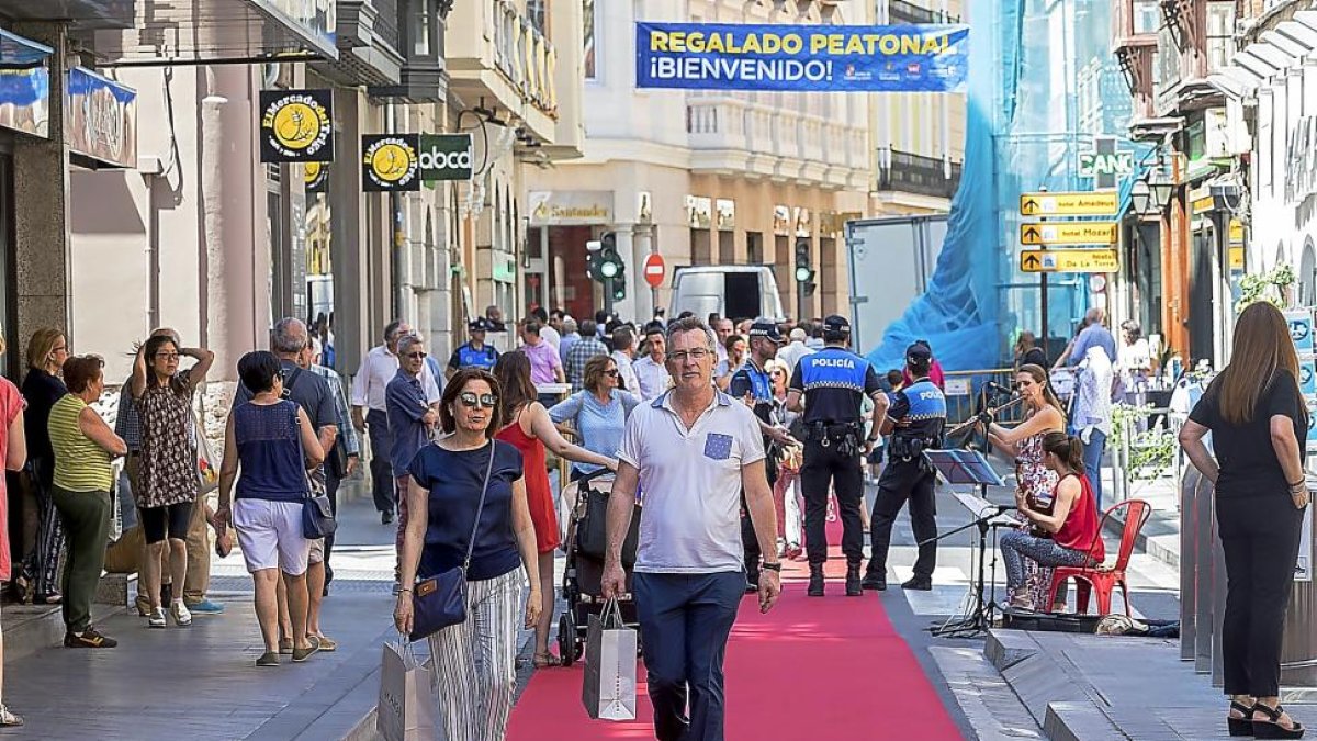 Dos compradores pasean por la recién peatonalizada calle Regalado sobre la alfombra roja instalada para la ocasión.-PABLO REQUEJO