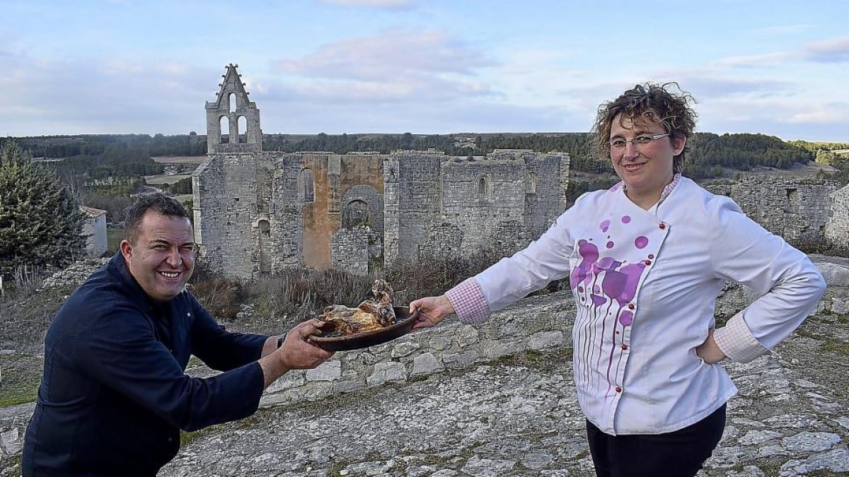 Modesto y Yolanda tiran del lechazo asado, estrella gastronómica de la casa, ante otro emblema de la localidad, el Monasterio de la Armedilla, que está situado a las afueras de Cogeces del Monte.-ARGI