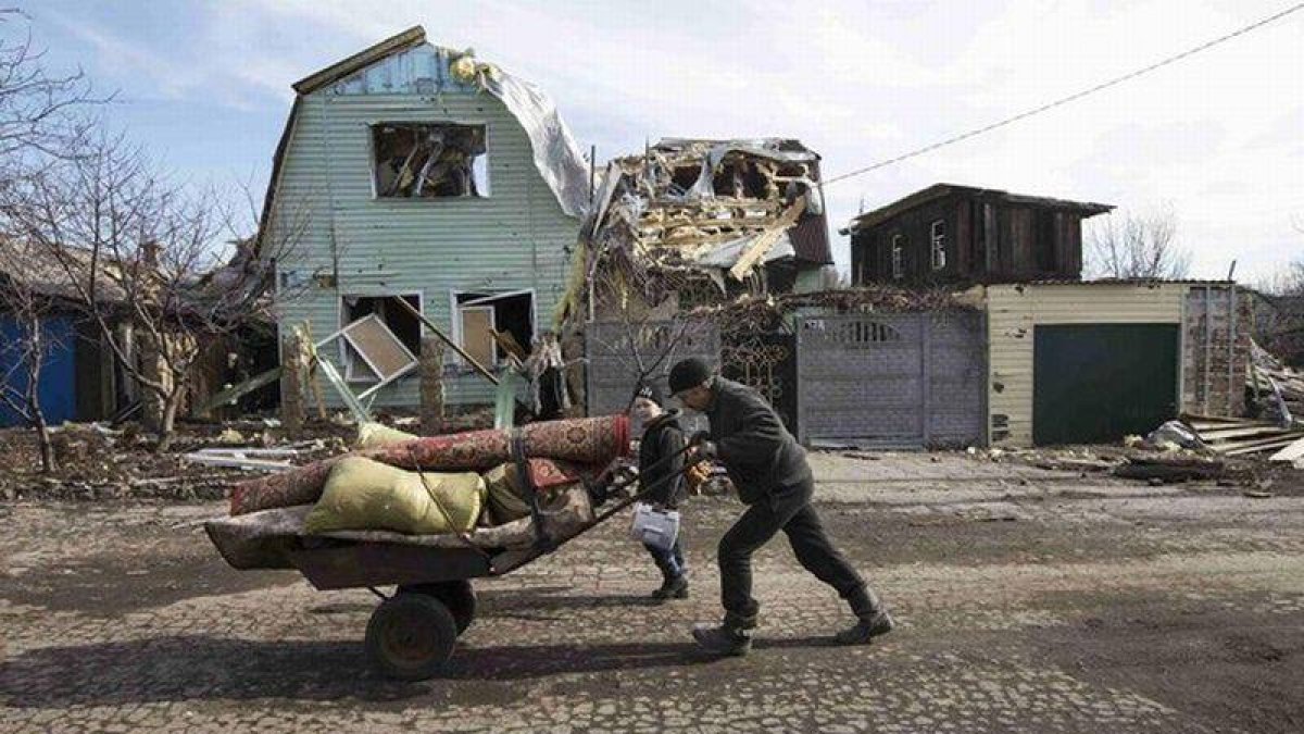 Un hombre empuja una carretilla ante una vivienda destruida por los combates en la ciudad de Debáltsevo , Ucrania.-Foto: REUTERS / BAZ RATNER