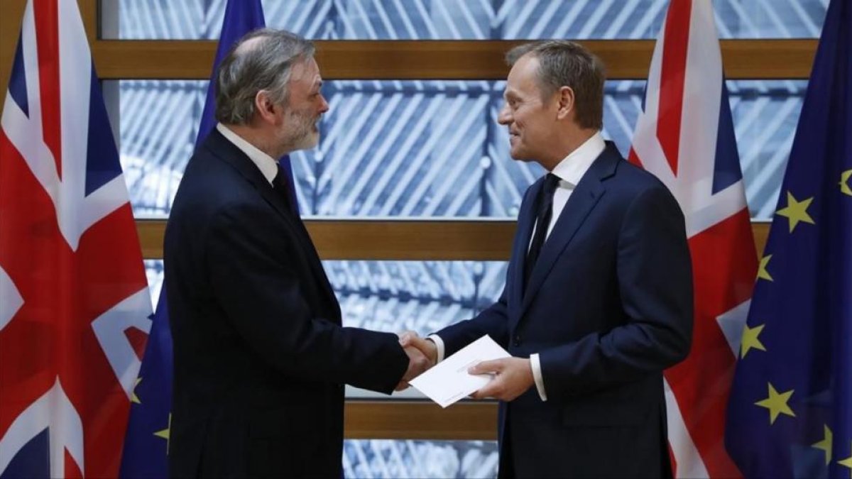 El embajador británico en la UE, Tim Barrow, entrega la carta de Theresa May al presidente del Consejo Europeo, Donald Tusk.-YVES HERMAN / REUTERS