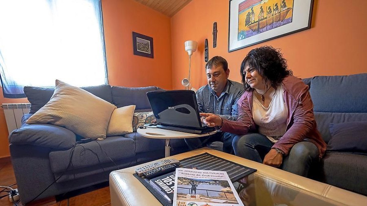 Enrique Seoane y Rosana de Castro, trabajando con el ordendor en el salón de su vivienda de Castronuño.-PABLO REQUEJO