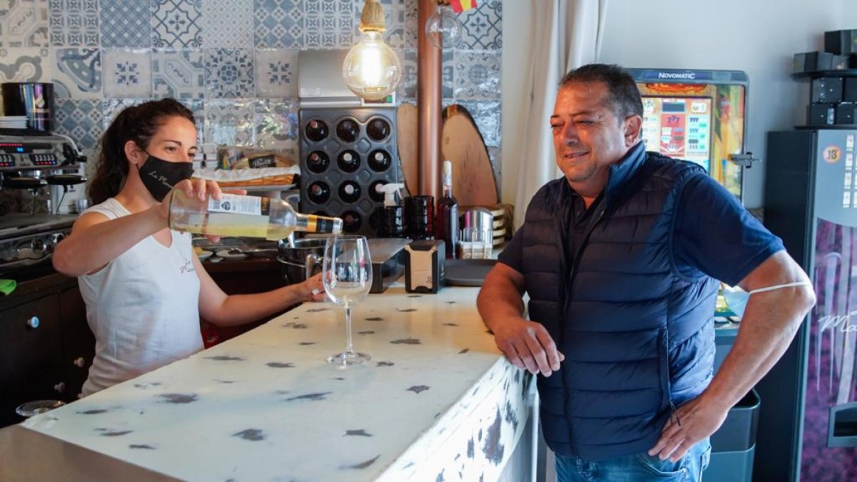 Una camarera atiende a un cliente en la barra de un bar de Valladolid. J. M. LOSTAU