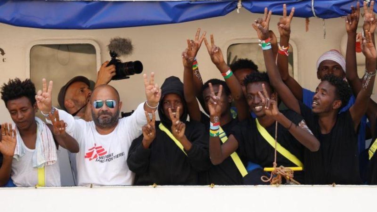 Inmigrantes y miembros de la tripulación del Aquarius celebran su llegada al puerto de La Valeta.-DARRIN ZAMMIT LUPI (REUTERS)