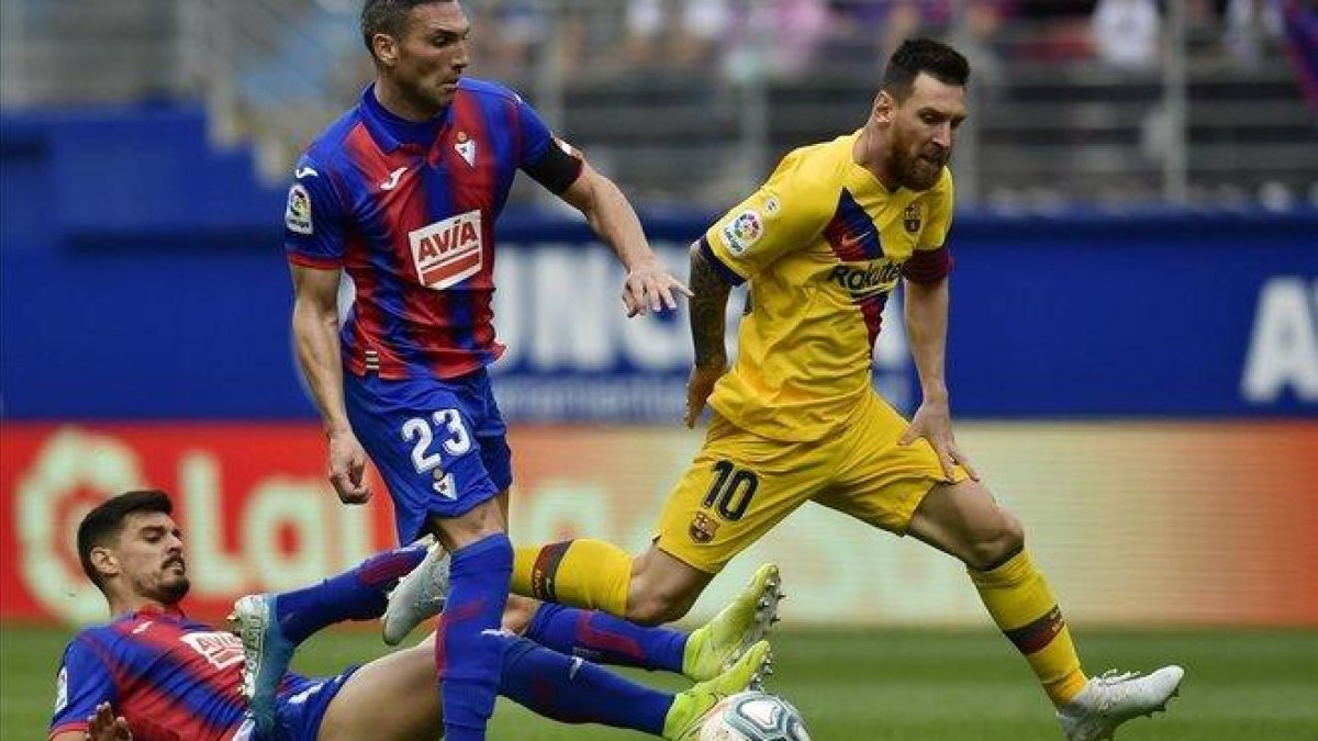 Messi desborda a dos jugadores del Eibar en el partido del sábado.-ÁLVARO BARRIENTOS (AP)
