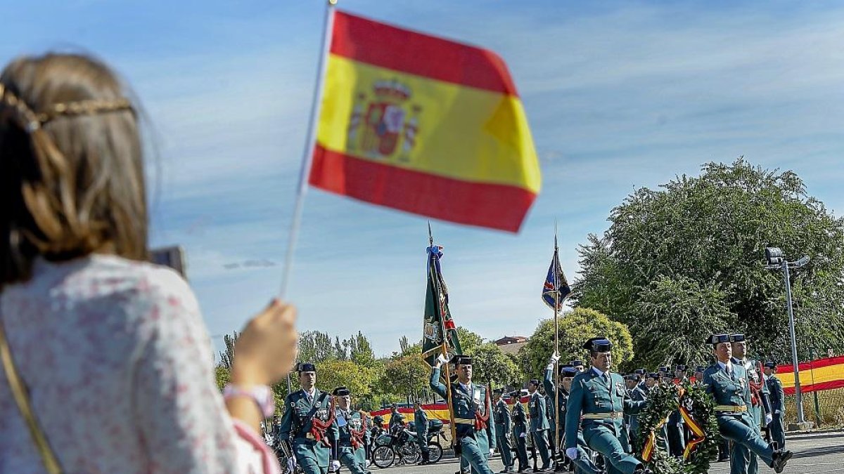 Una niña sujeta una bandera de España durante el acto de celebración de la fiesta de la Virgen del Pilar en Valladolid.-J.M. LOSTAU
