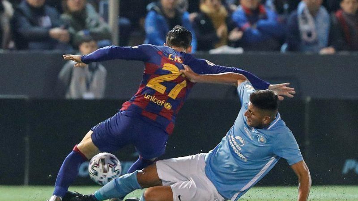El delantero del FC Barcelona Carles Pérez (i) disputa un balón con Mariano Gómez, defensa argentino del UD Ibiza, el centrocampista Josep Caballé (d).-EFE