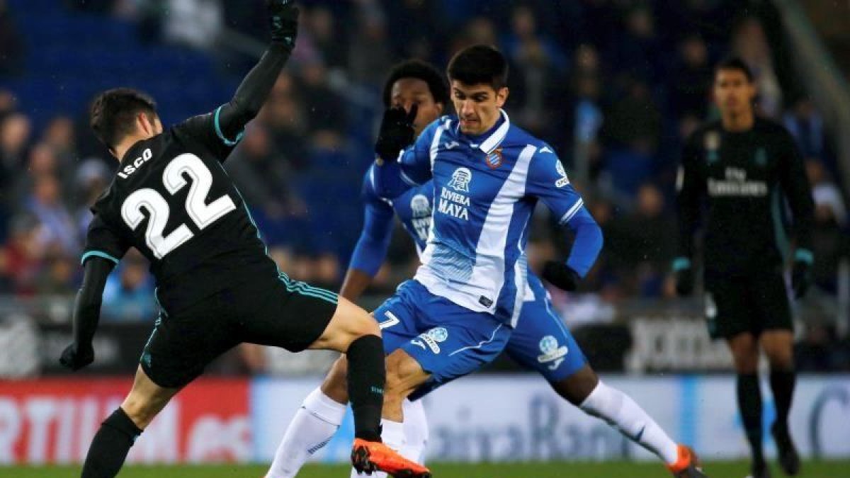 El delantero del Espanyol, Gerard Moreno (d), pelea un balón con el centrocampista del Real Madrid, Isco Alarcón (i), durante el partido de la vigesimosexta jornada de liga que se disputa en el RCDE Stadium.-EFE