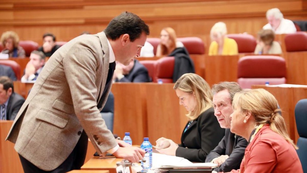 El procurador popular Raúl de la Hoz junto a la vicepresidenta de la Junta y consejera de Empleo, Rosa Valdeón, y el consejero de la Presidencia, José Antonio de Santiago-Juárez; durante el Pleno de las Cortes de Castilla y León.-ICAL