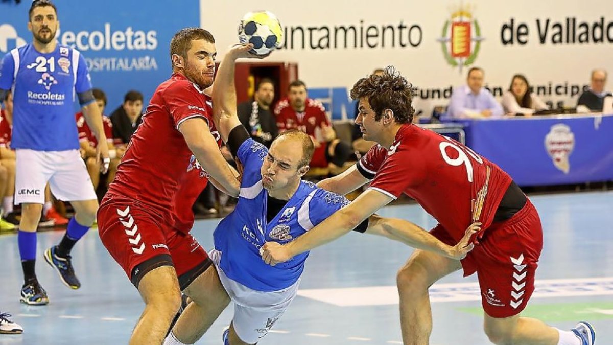 AdriánFernández se pelea con dos jugadores del Alcobendas para intentar lanzar a portería.-J. M. LOSTAU
