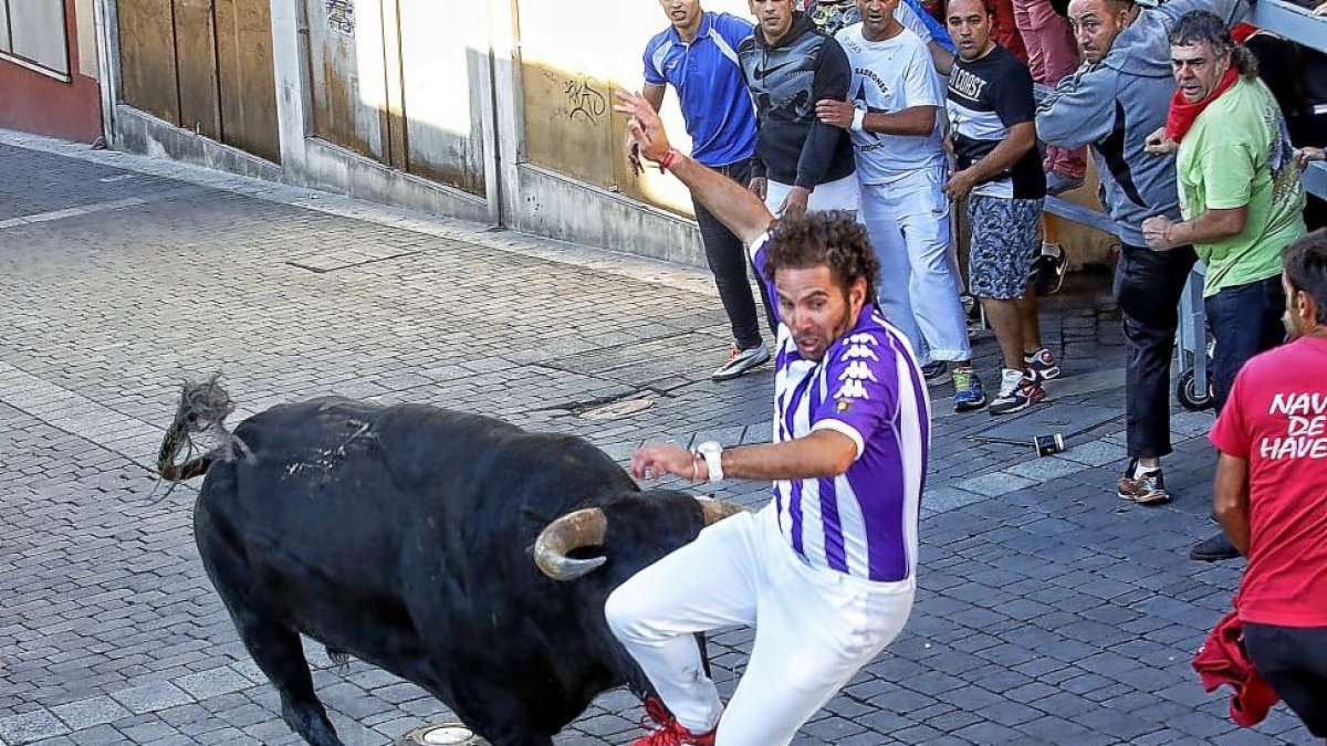 Un toro de Yerbabuena da un buen susto a uno  de los corredores del encierro.-ICAL