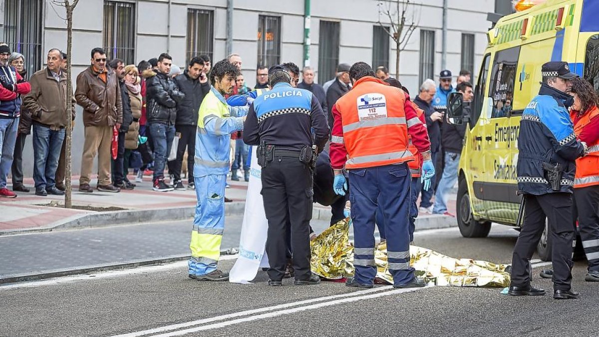 Policías municipales y personal de Sacyl cubren el cuerpo sin vida del peatón atropellado ayer en Gondomar.-MIGUEL ÁNGEL SANTOS