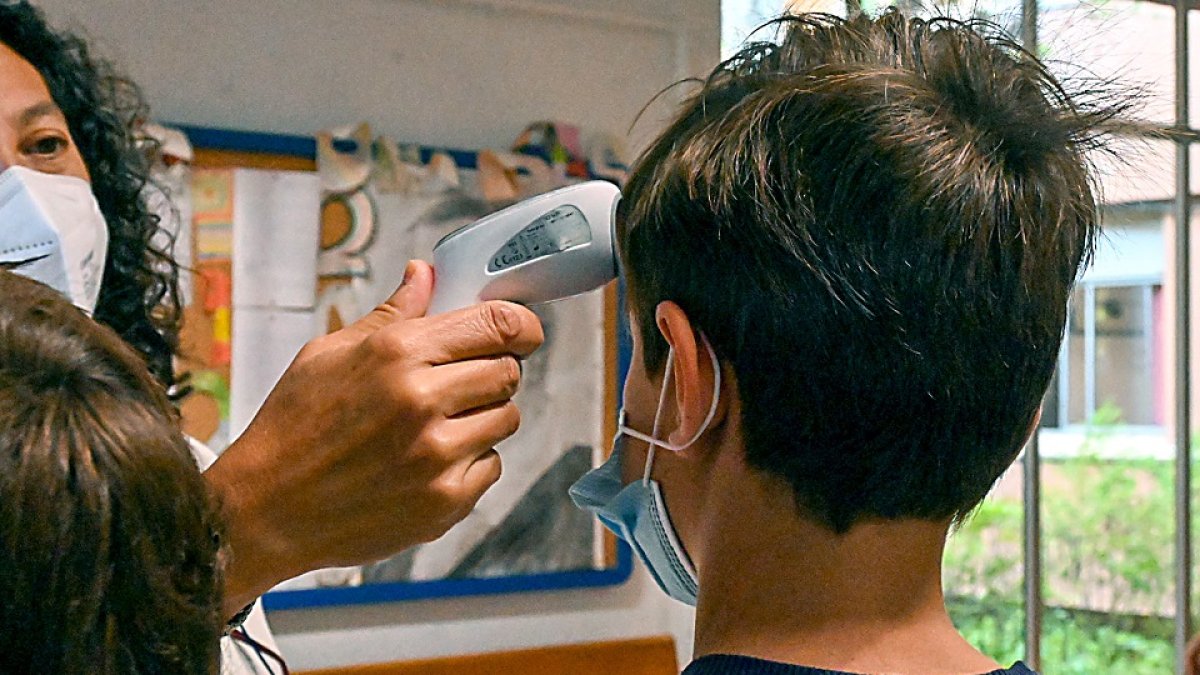Una profesora toma la temperatura a un alumno en una de las aulas de la Comunidad Autónoma. EL MUNDO