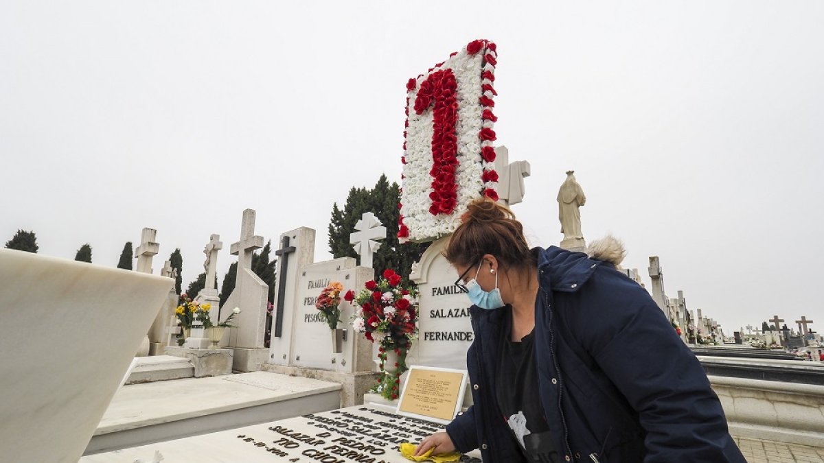 Una mujer limpia la lápida de un ser querido en el cementerio de El Carmen. MIGUEL ÁNGEL SANTOS