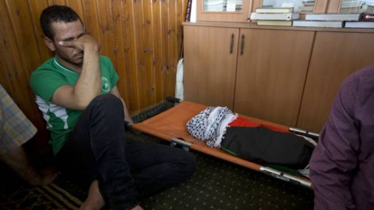 Un palestino, junto al cuerpo de Alí Dawabsheh, el bebé muerto en el incendio.-Foto: AP / MAJDI MOHAMMED