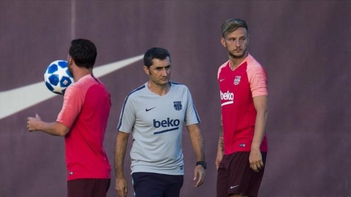 Valverde junto a Messi y Rakitic en el entrenamiento de este lunes.-JORDI COTRINA