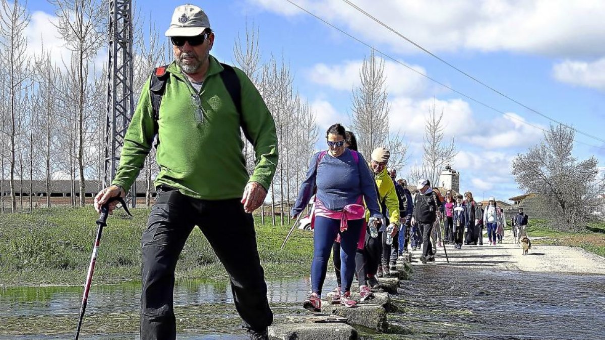Un grupo de caminantes cruza uno de los arroyos de a ruta.-L.P.