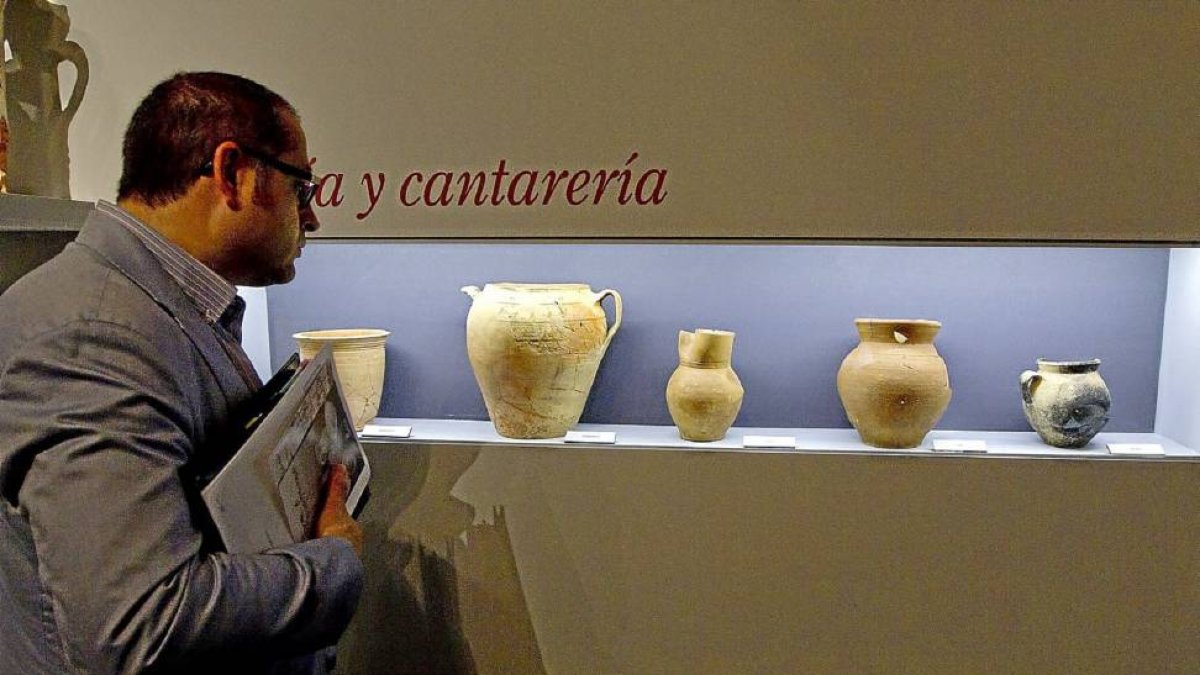 Un asistente observa la exposición ‘Entre pucheros’, de alfarería del siglo XVI.-J.M. Lostau