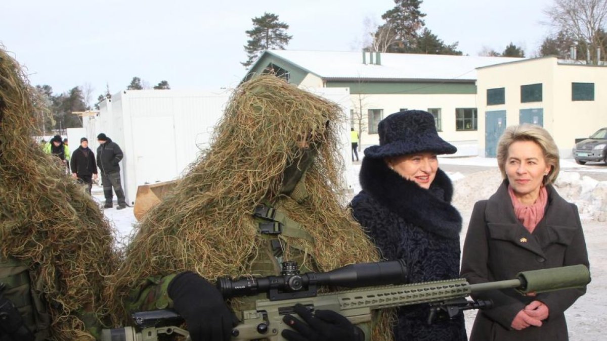 La ministra alemana de Defensa, Ursula von der Leyen (a la derecha), y la presidenta de Lituania,  Dalia Grybauskaite, junto a un soldado en la ceremonia de bienvenida a las tropas de la OTAN.-PETRAS MALUKAS