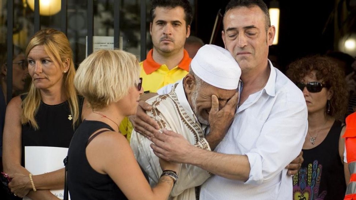La fotografía de Jordi Cotrina en la que Javier Martinez, padre de Xavi, la víctima de tres años del atentado de la Rambla, abraza a Dris Salym, el imán suplente de Rubí.-JORDI COTRINA