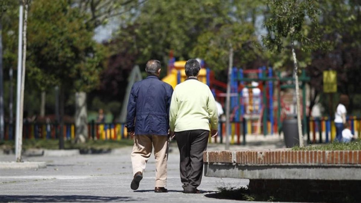 Dos personas mayores andan por la calle. E. M.