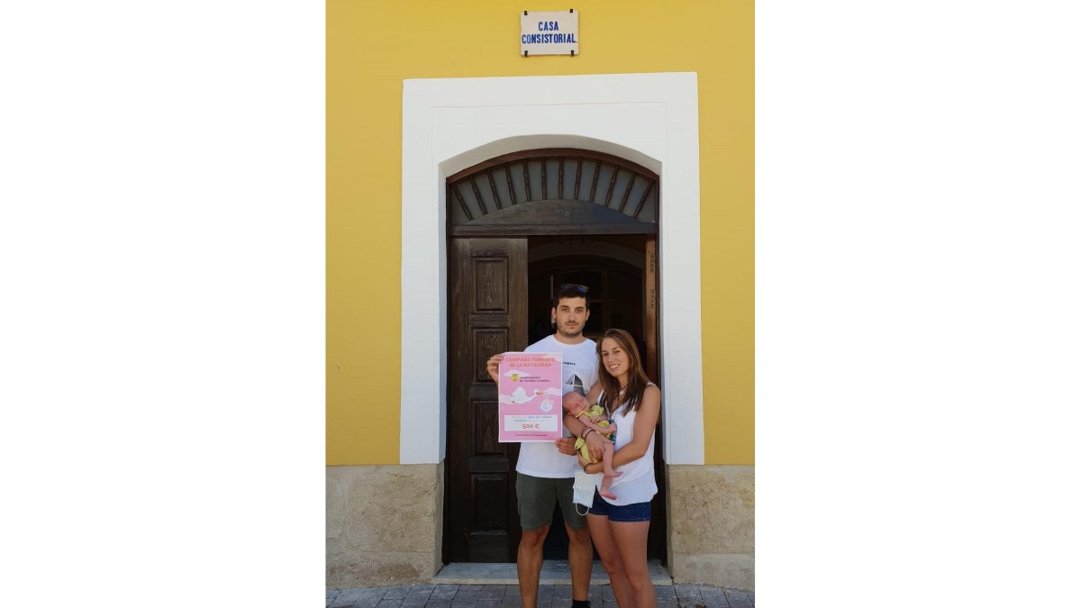 Una pareja de Valoria la Buena con su hijo recoge el cheque bebé dotado de 500 euros. EL MUNDO
