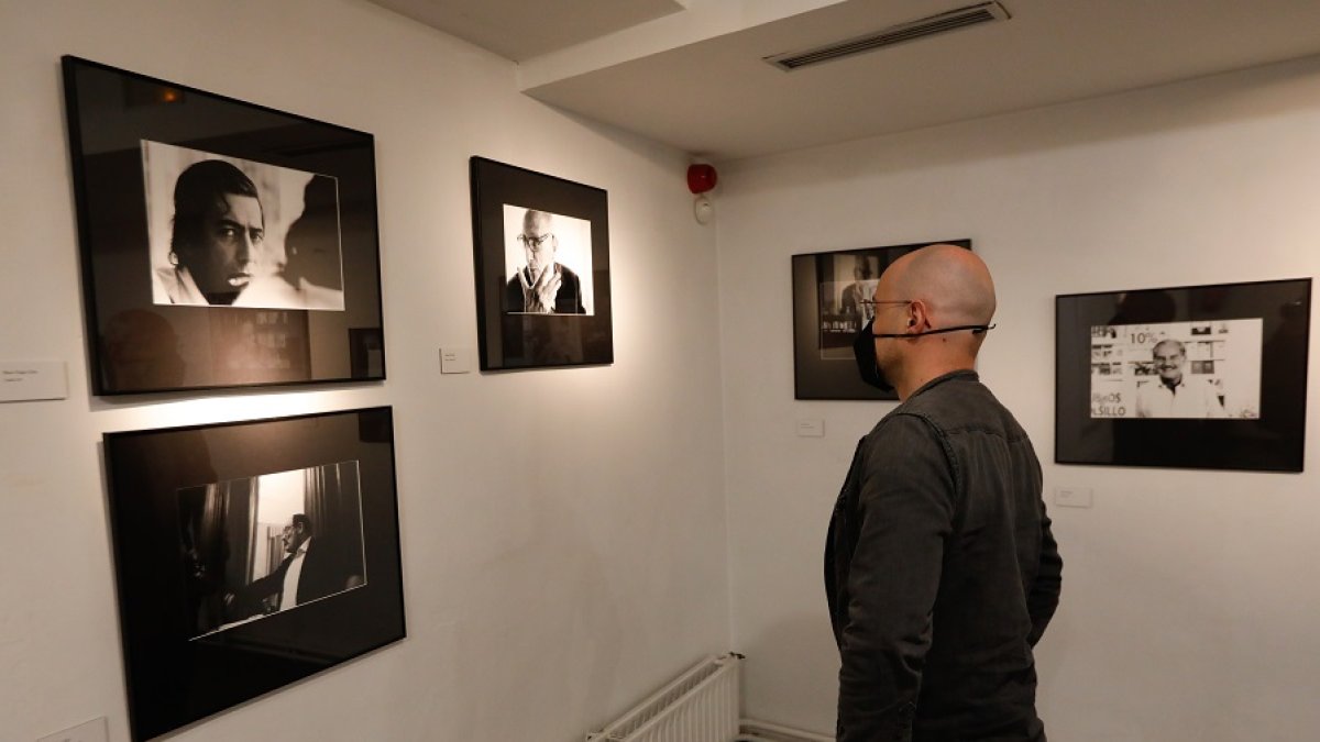 Un hombre contempla retratos de Vargas Llosa, Eco, Guillén y Fuentes. | LOSTAU