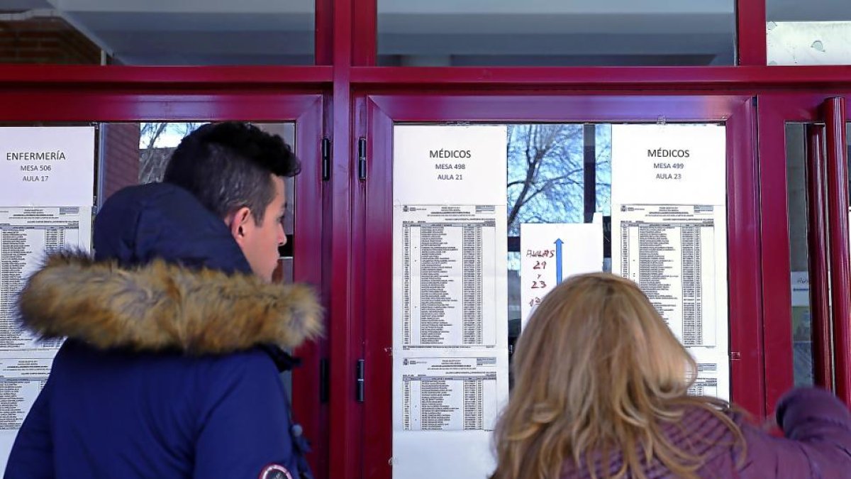 Dos opositores consultan el listado del examen expuesto en la Universidad de Valladolid.-ICAL