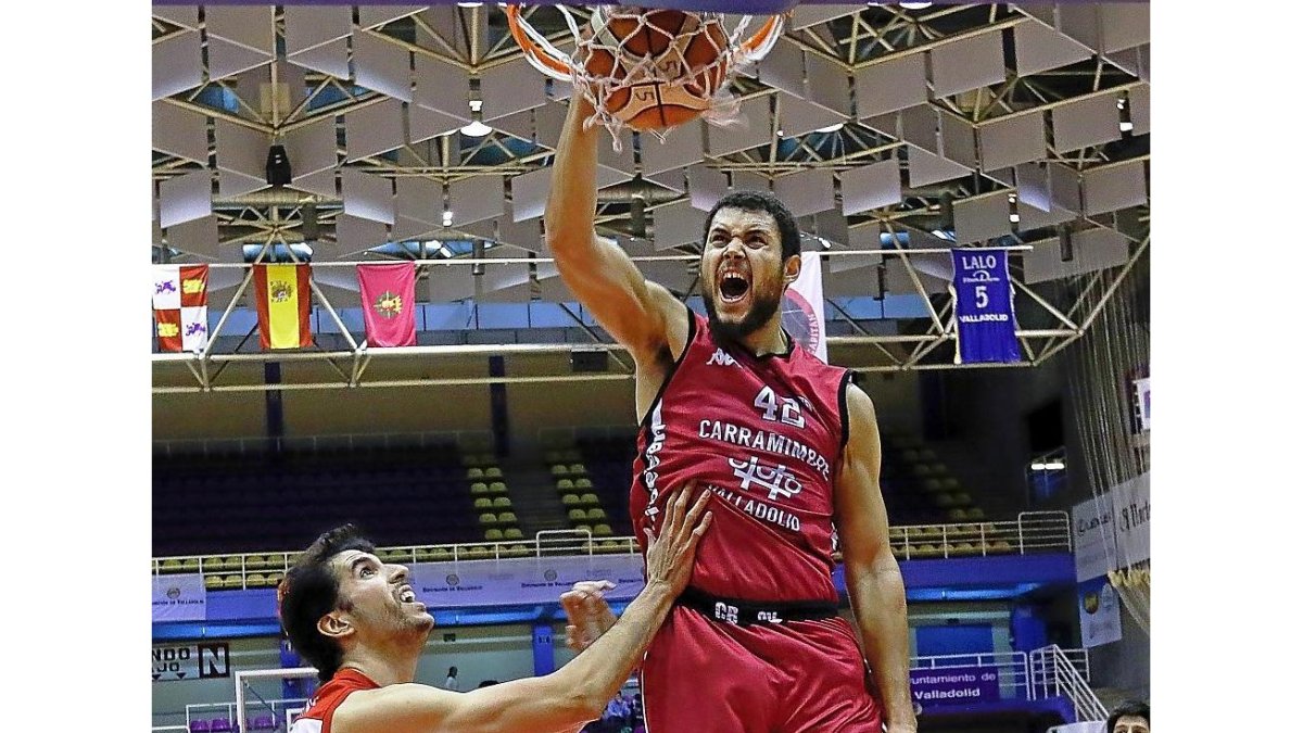 Hayes ‘machaca’ el aro ante la mirada de un rival durante el encuentro ante elGranada.-J.M. LOSTAU