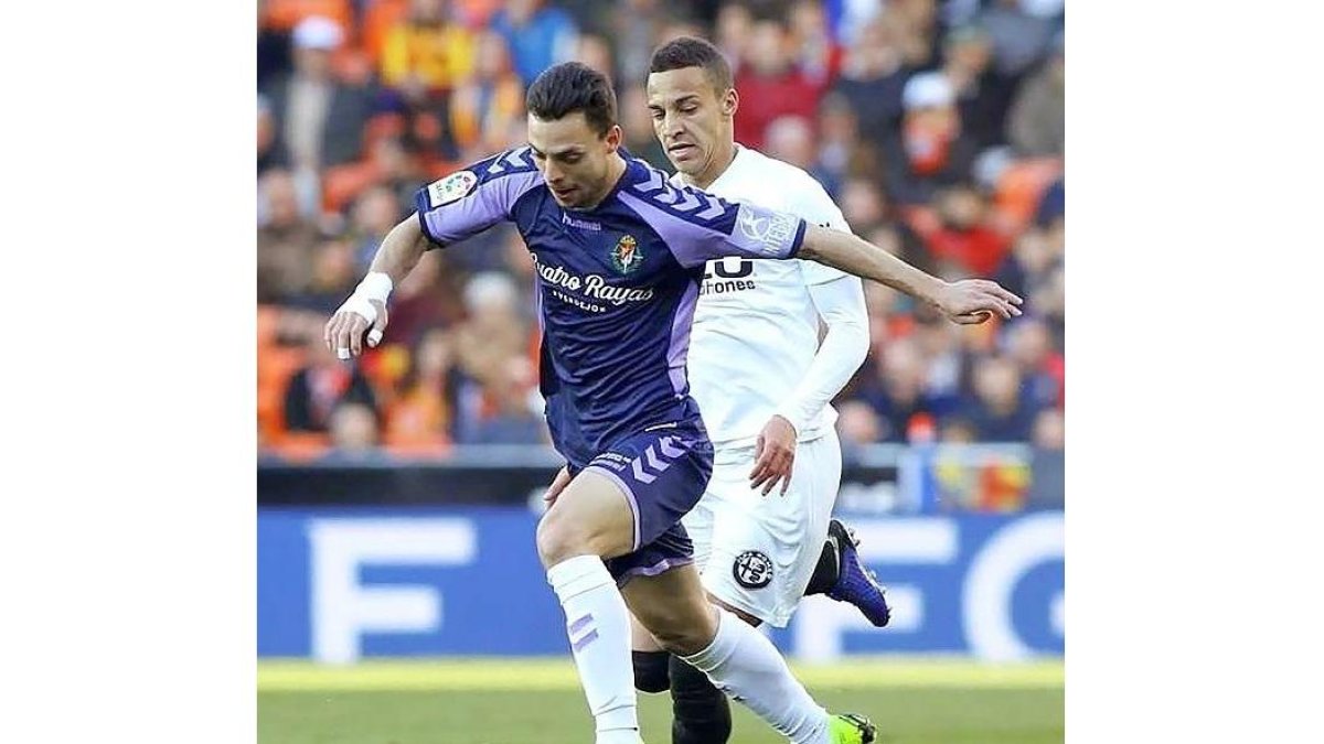 Óscar Plano se lleva el balón ante la presencia de Rodrigo, ayer, en Mestalla.-PHOTO DEPORTE