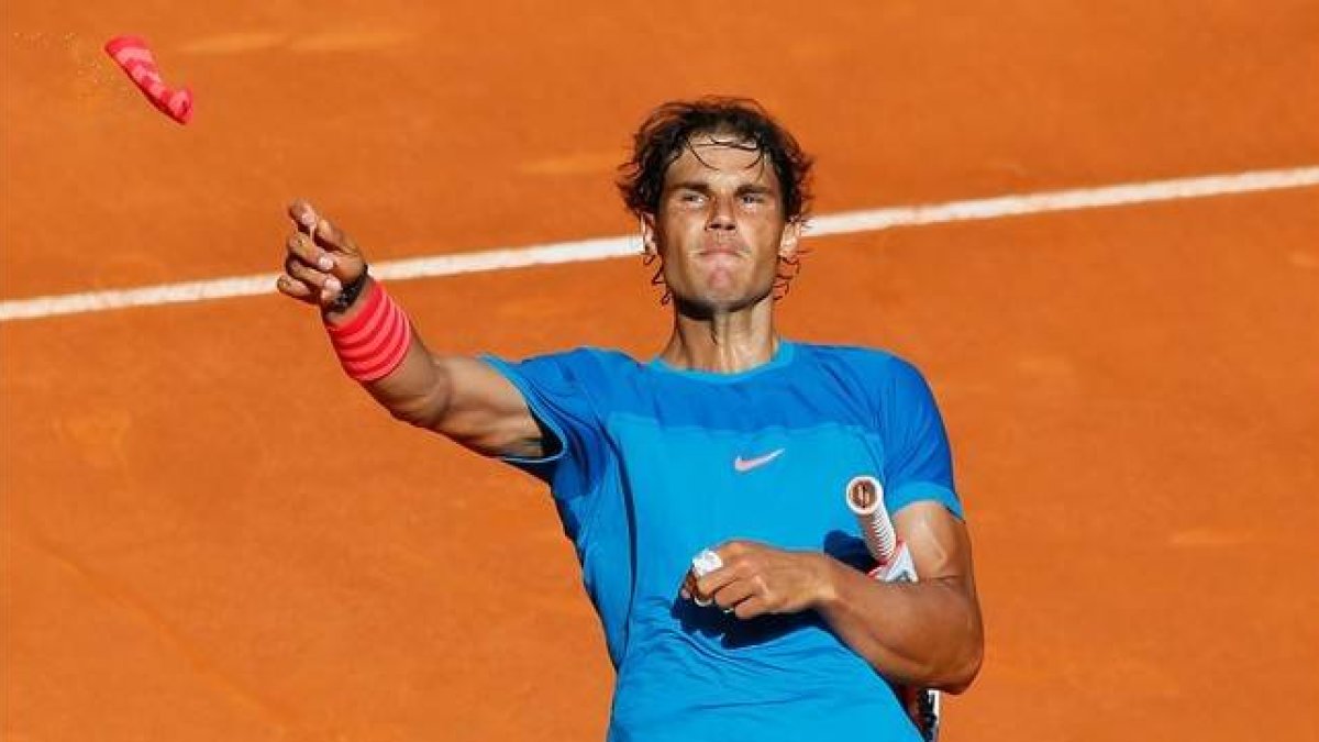 Nadal lanza una de sus muñequeras al público de la Caja Mágica tras derrotar a Dimitrov.-Foto: EFE / JUANJO MARTÍN