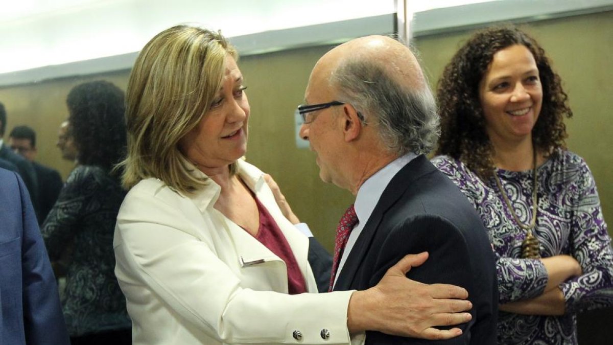 La consejera de Economía y Hacienda, Pilar del Olmo, saluda al ministro de Hacienda, Cristóbal Montoro, al comienzo de la reunión del Consejo de Política Fiscal y Financiera.-ICAL