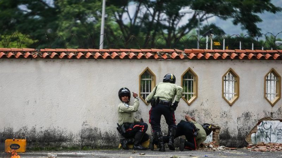 Oficiales de la Policía Municipal de Sucre se protegen durante enfrentamientos entre manifestantes y civiles no identificados.-EFE