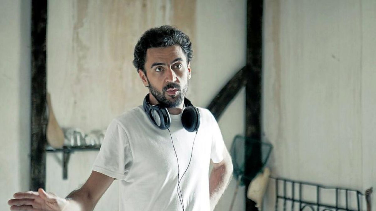 El director Javier Roldán junto a un fotograma del cortometraje ‘Hermanos’.-ICAL